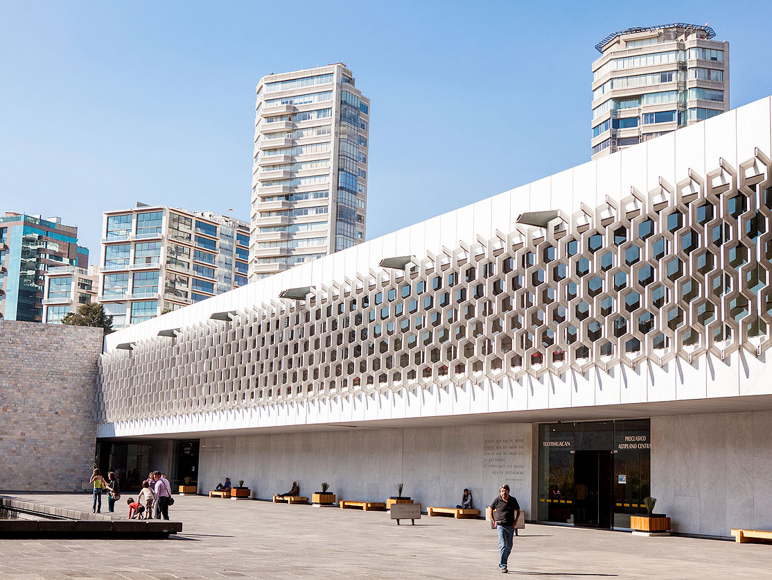 Courtyard and exterior of National Museum of Anthropology in Mexico City with skyline in background