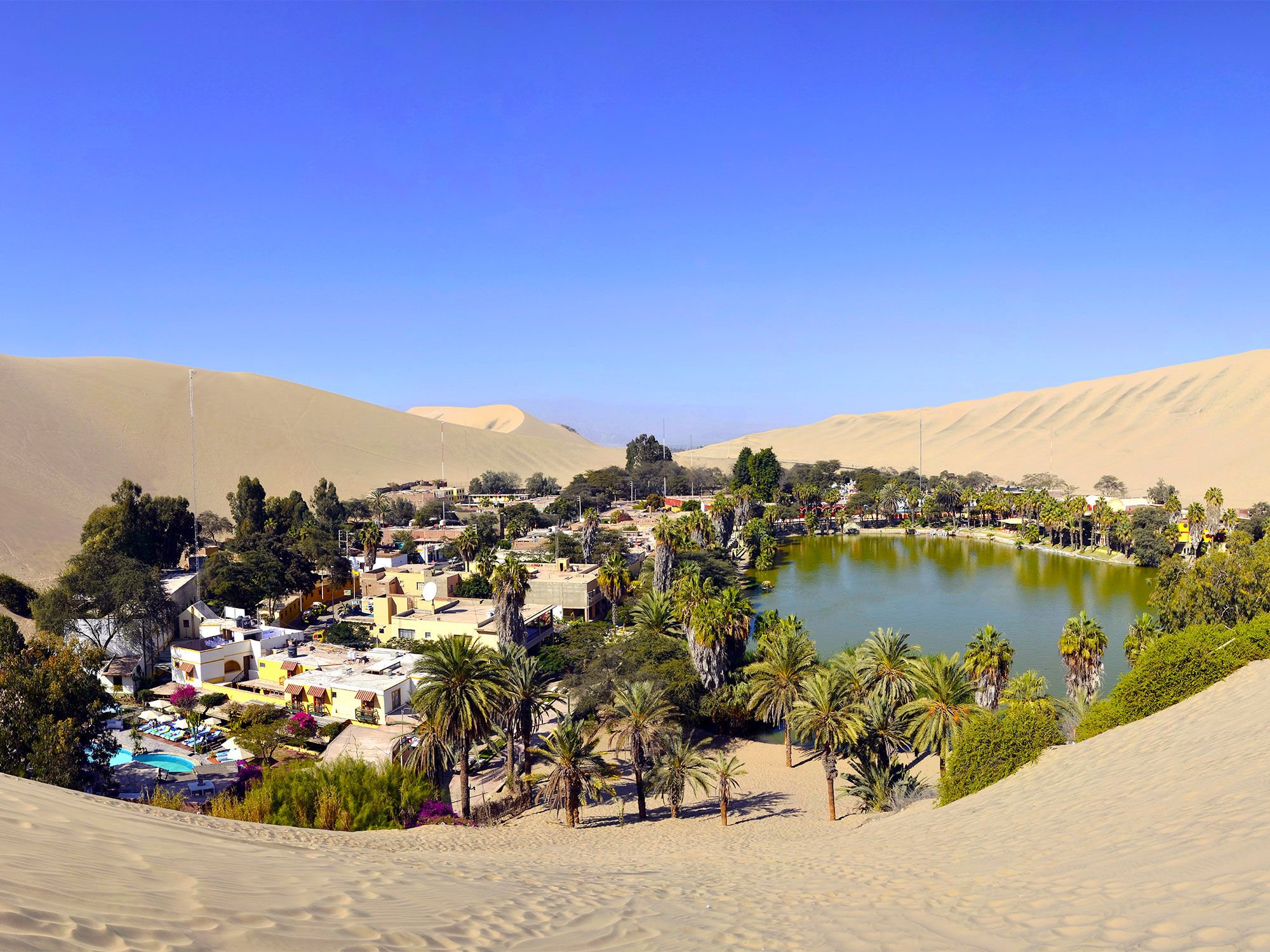 Overview of Huacachina, Peru, surrounded by sand dunes