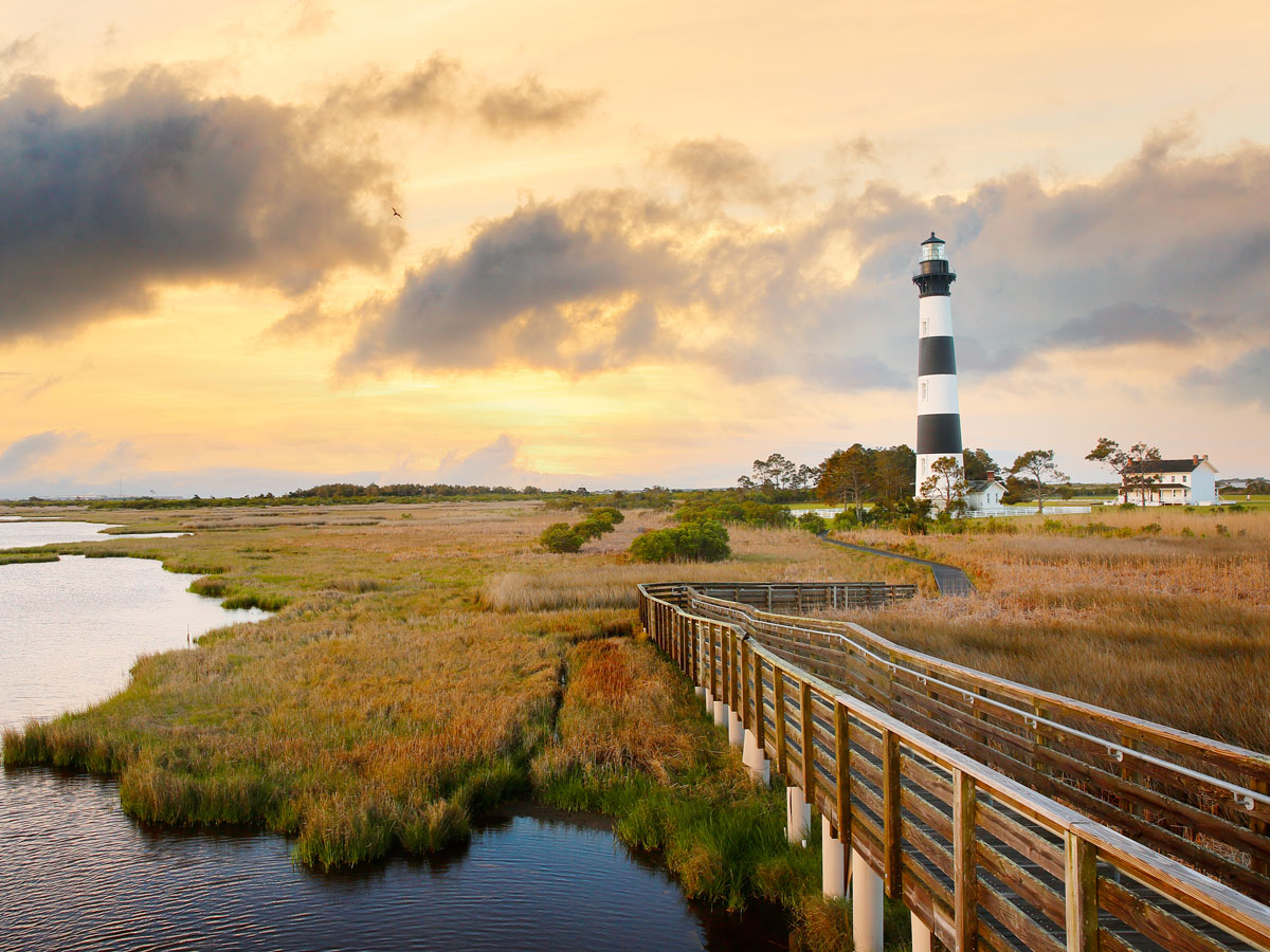 Wooden pathway leading to striped lighthouse on Roanoke Island, North Carolina