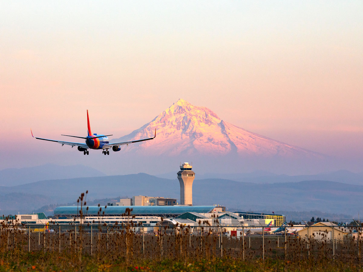 Southwest Airlines airplane landing with snow-capped peak in background