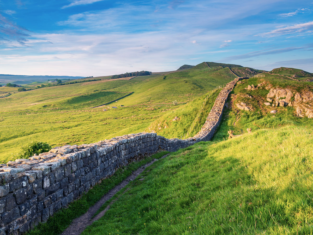 Hadrian's Wall on rolling green hills in British countryside, seen from above