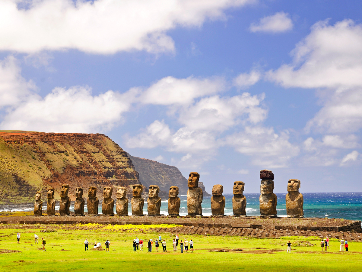 Easter Island moai statues with backs to sea and onlookers