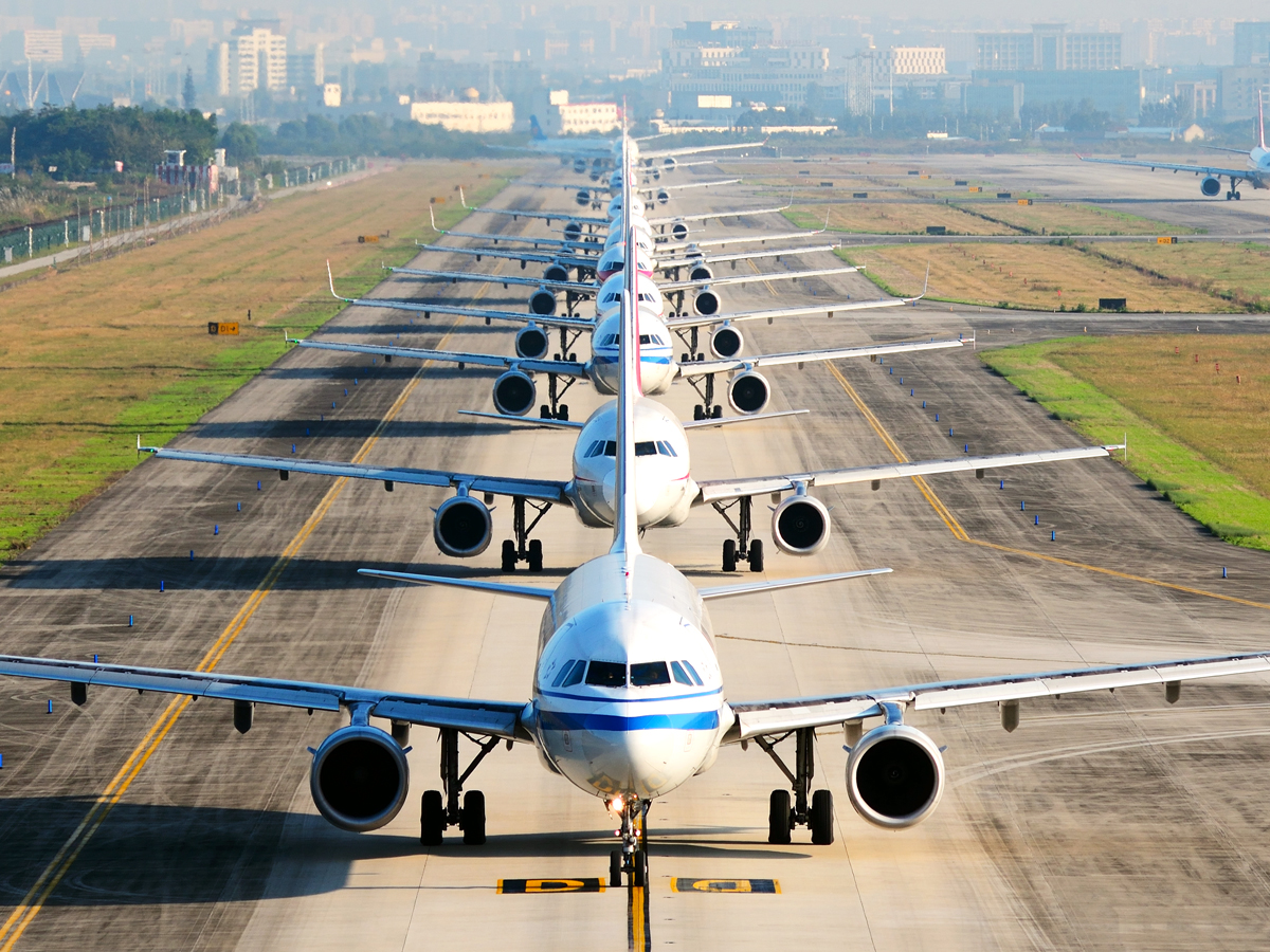 Airplanes lined up on airport runway, seen from above