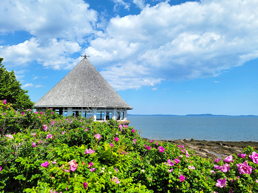 Cone-shaped building surrounded by flowers overlooking coast of Ministers Island in New Brunswick, Canada