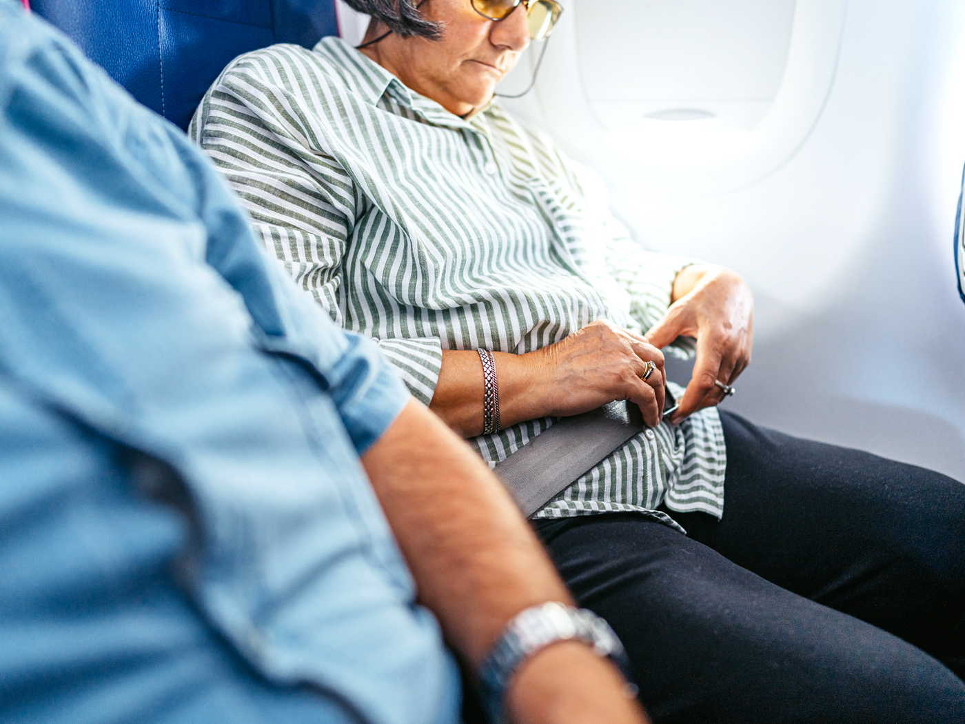 Airplane passenger fastening seatbelt