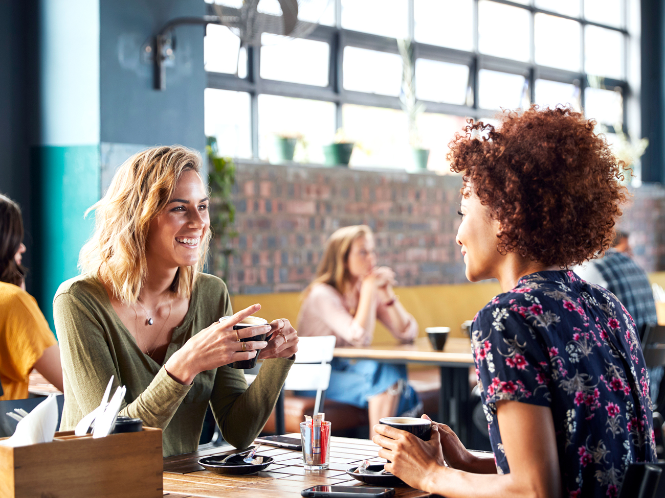 Two people drinking coffee at cafe