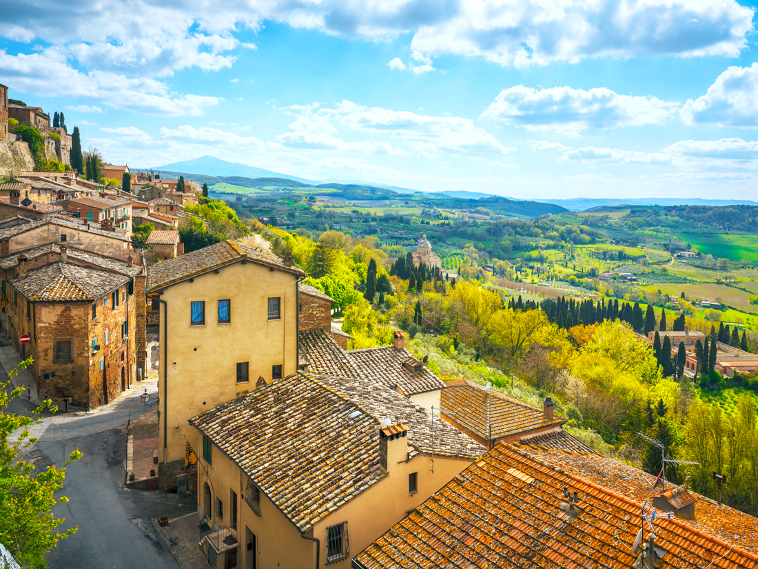 Homes with red-tiled roofs overlooking hills of Tuscany, Italy