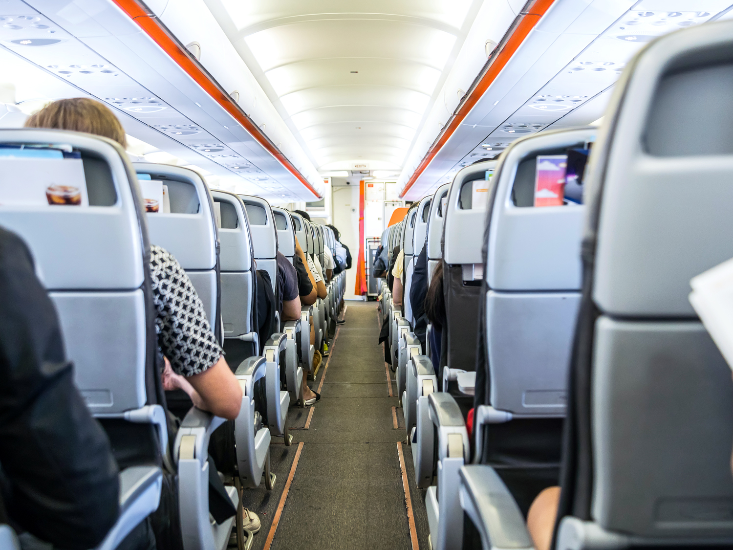 View of single-aisle aircraft cabin from back to front