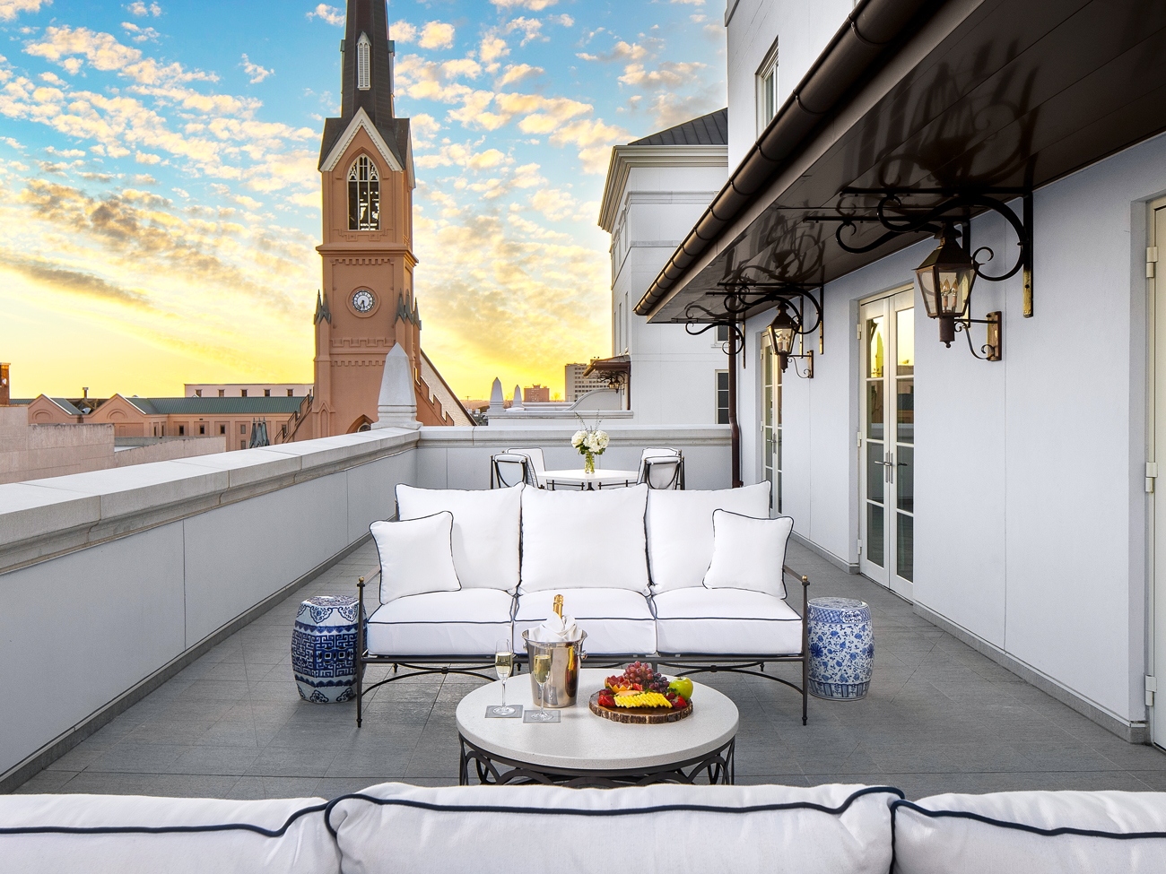Balcony of Owner's Suite at Hotel Bennett overlooking church tower and Charleston skyline at sunset