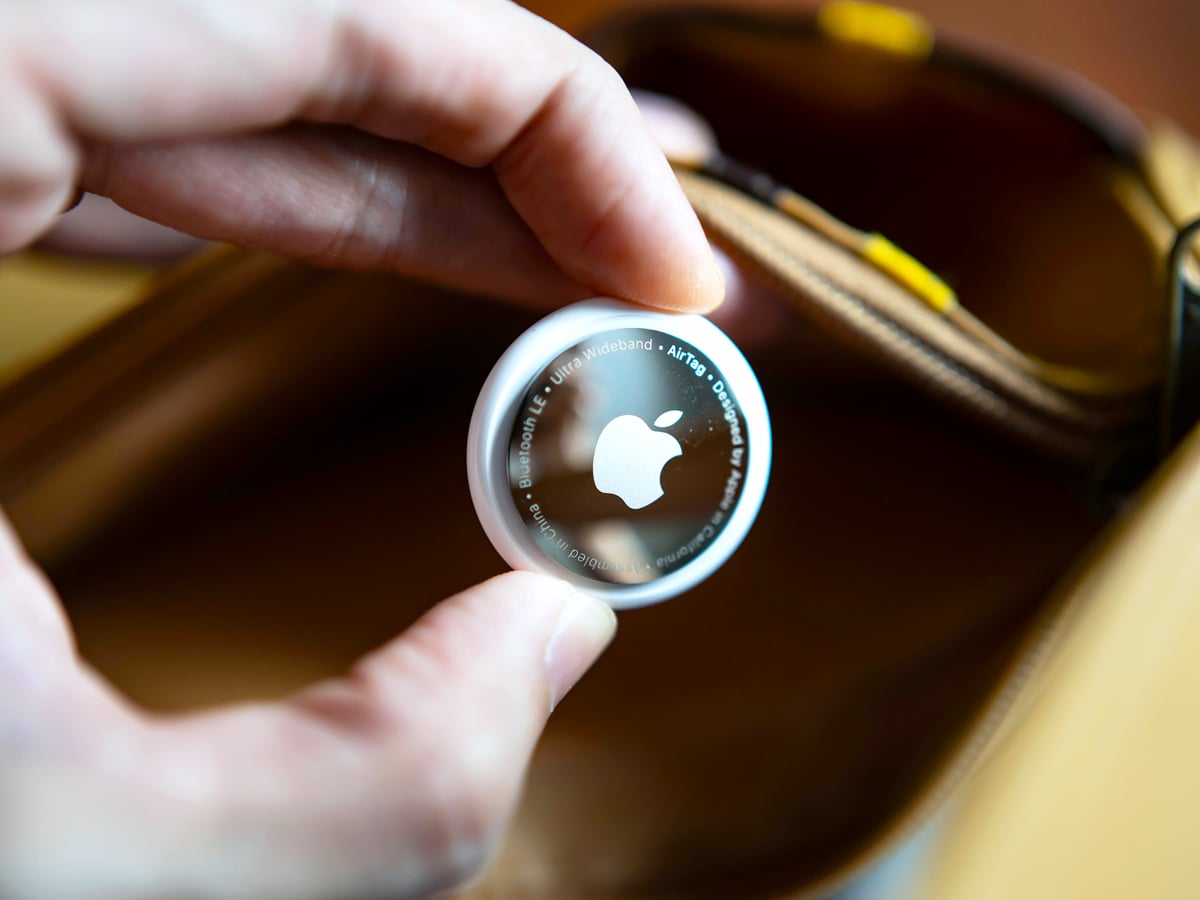 Close-up image of person holding Apple AirTag device