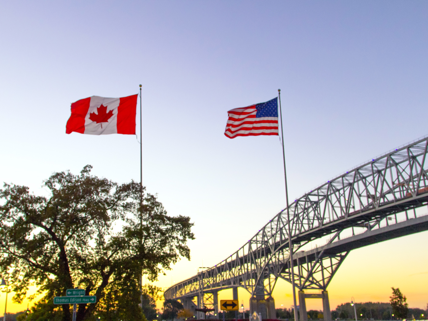 Canadian and American flags flying over International Blue Water Bridge Crossing