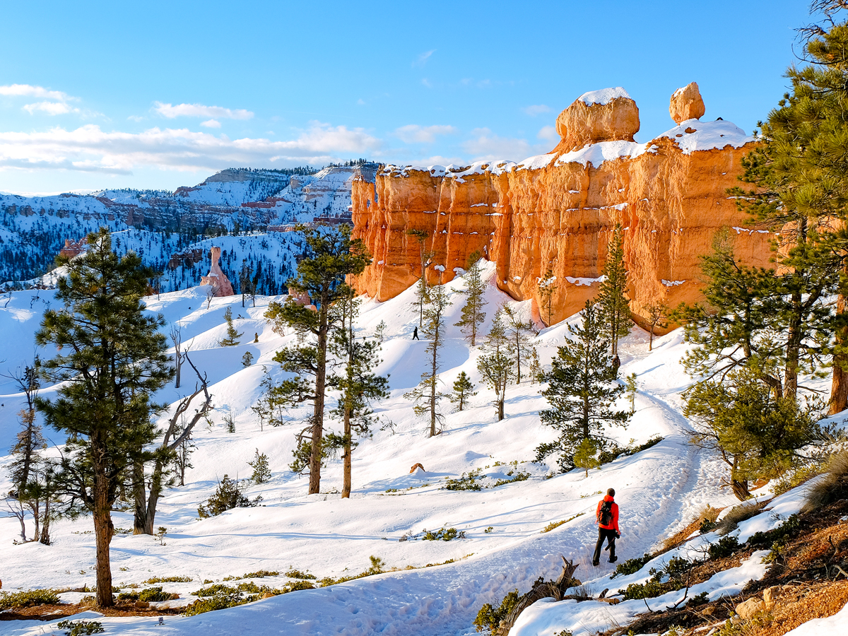 Hiker on snow-covered trail in Bryce Canyon National Park, Utah