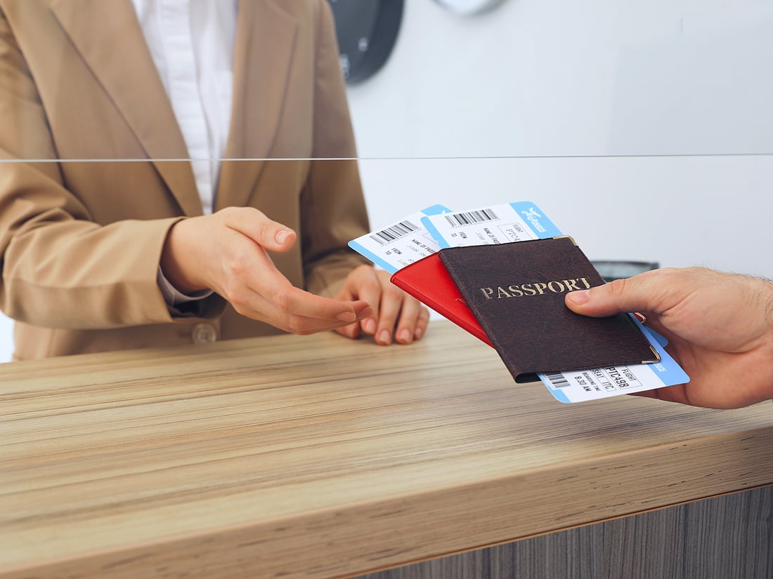 Airline agent handing passenger passports with boarding passes inside