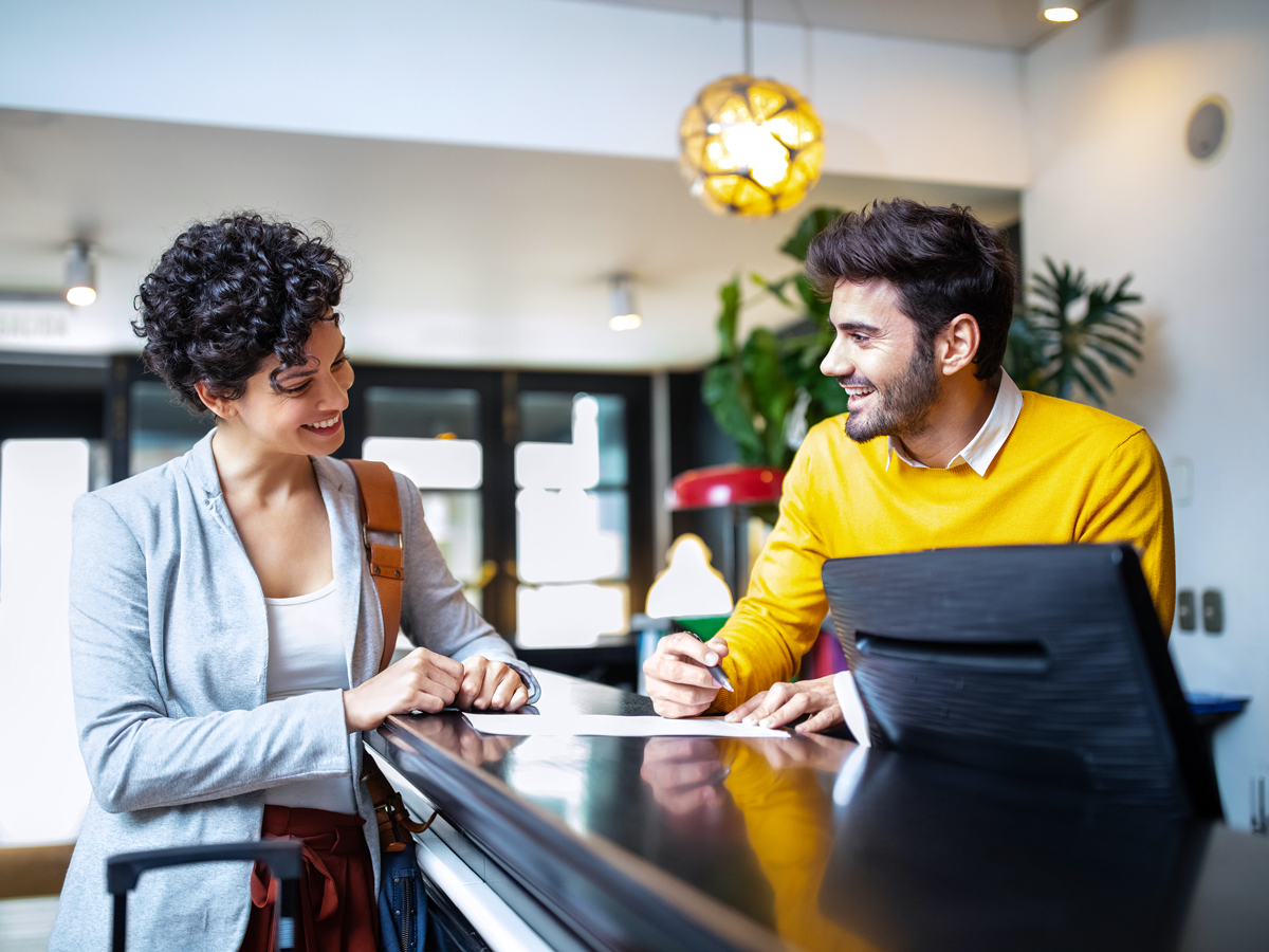Hotel guest talking to front desk employee