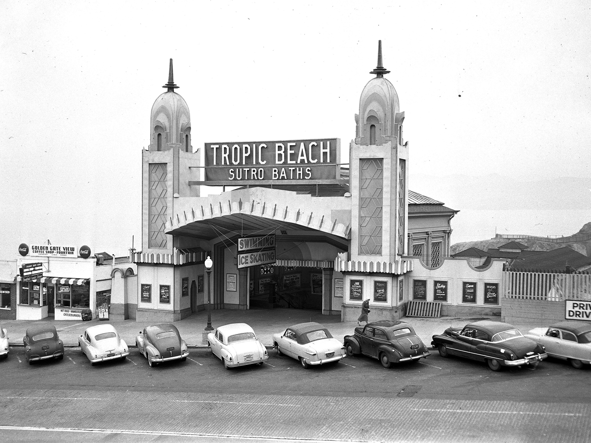Historical image of cars parked in front of Sutro Baths entrance