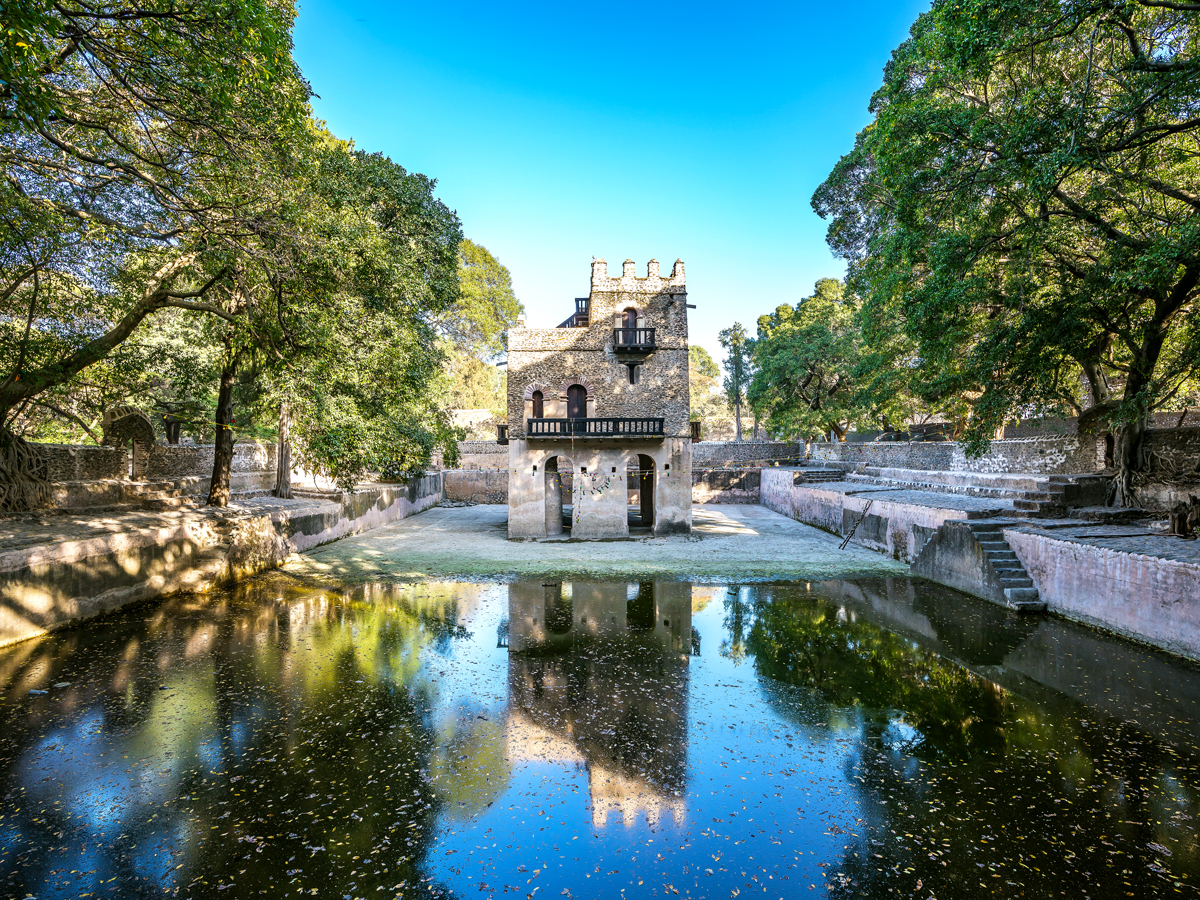 Church reflecting on shady pool in Gondar, Ethiopia