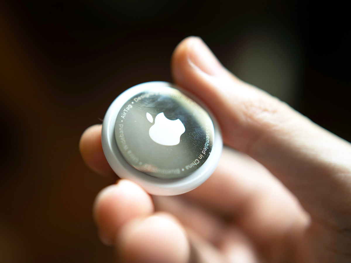 Close-up image of person holding Apple AirTag tracking device
