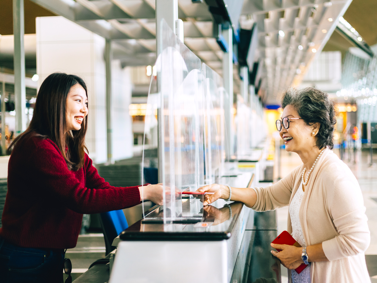 Traveler handing passport to airport check-in agent