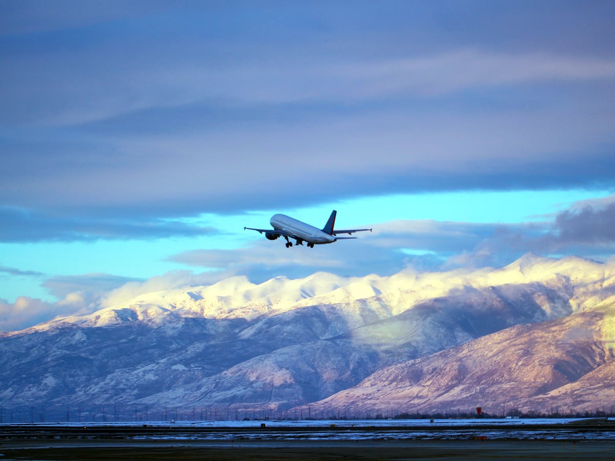 Aircraft departing runway with mountains in background