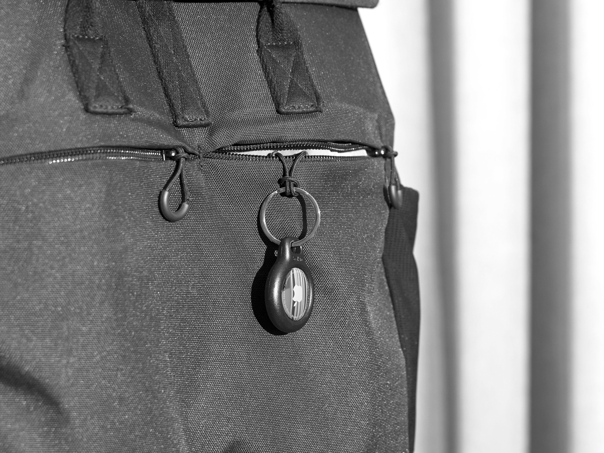 Apple AirTag tracking device affixed to traveler's bag