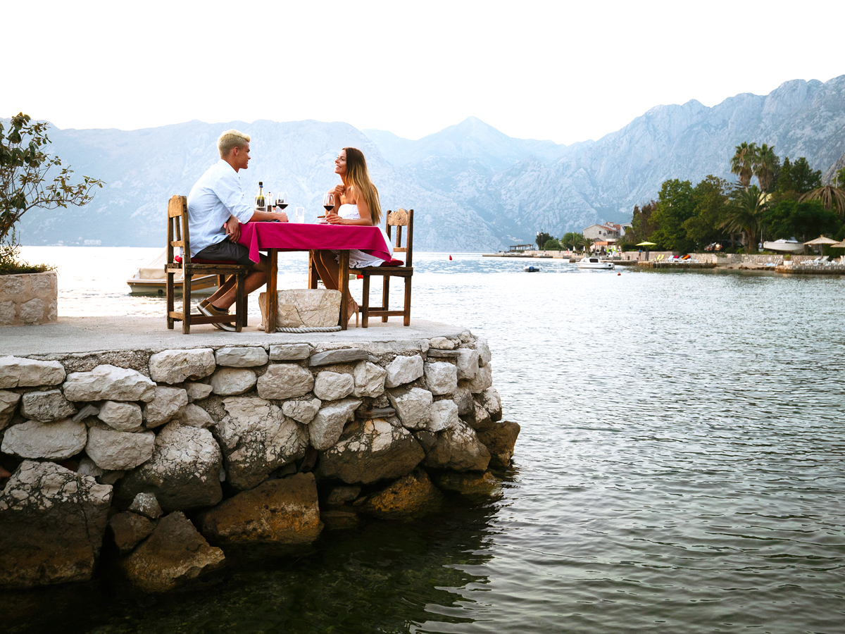 Couple dining at table overlooking the water