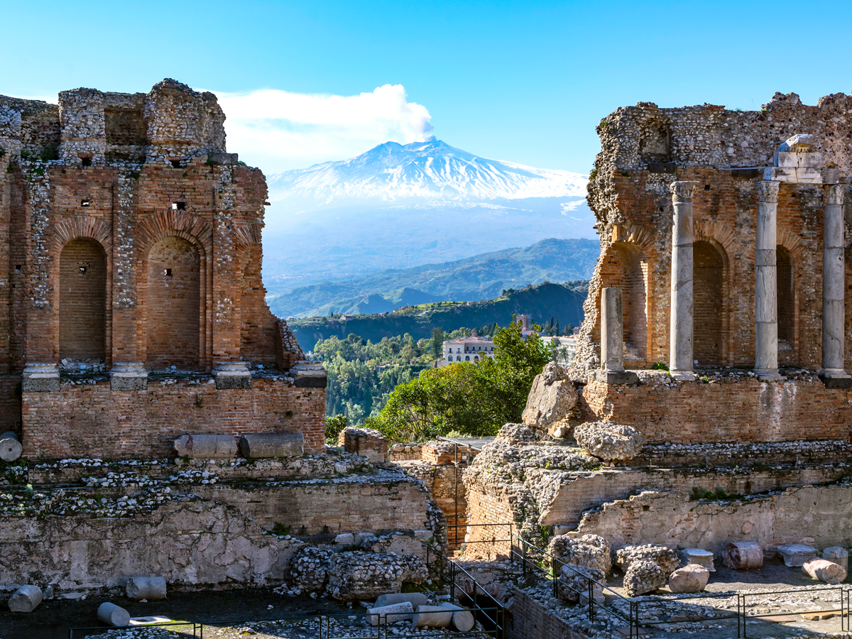 Ancient ruins framing view of Mount Etna in Sicily, Italy
