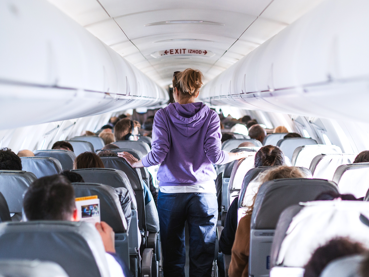 Passenger walking through aircraft aisle