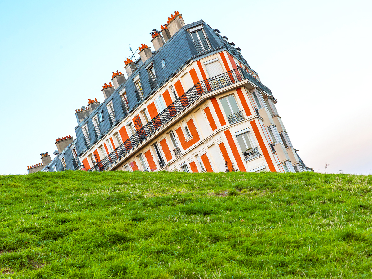 Sinking House behind grassy hillside in Montmarte, France