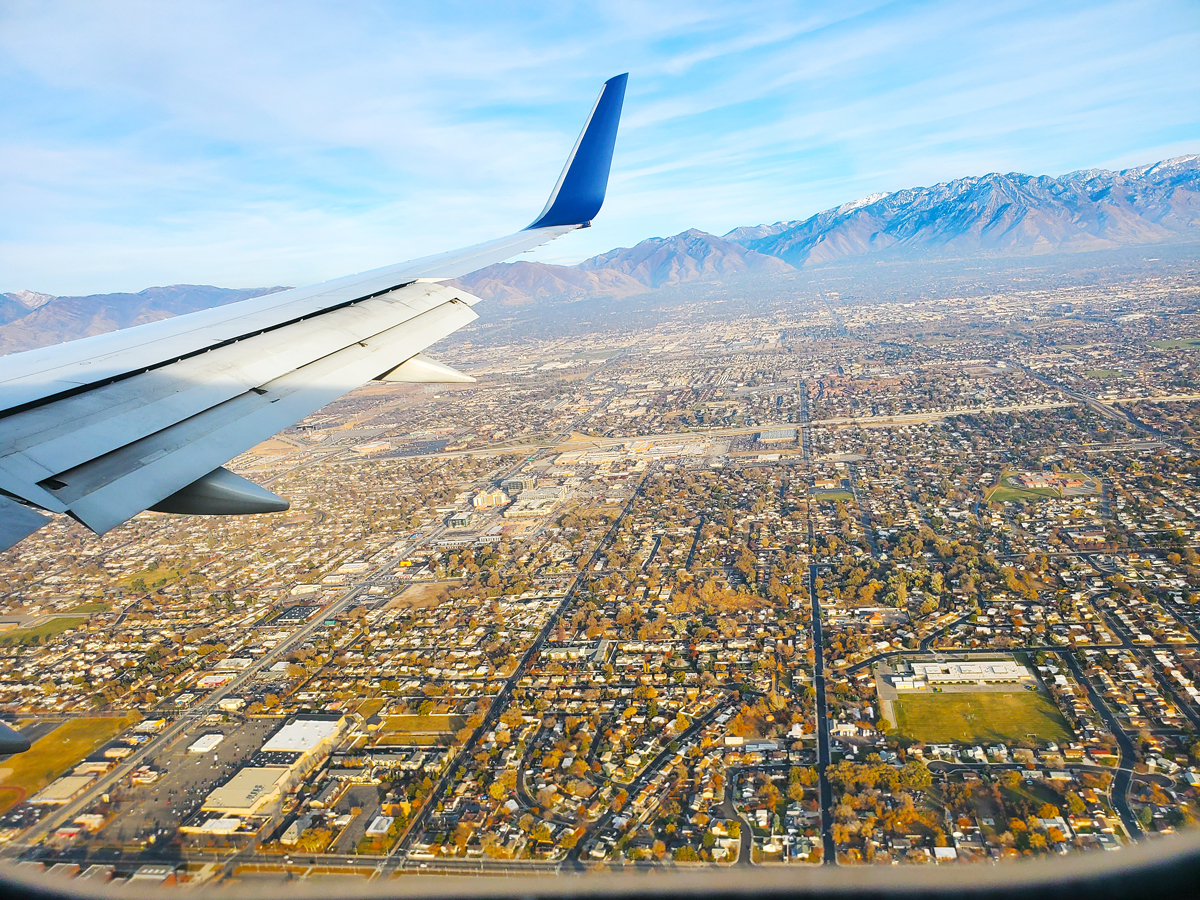 View of city and mountains outside airplane window during approach