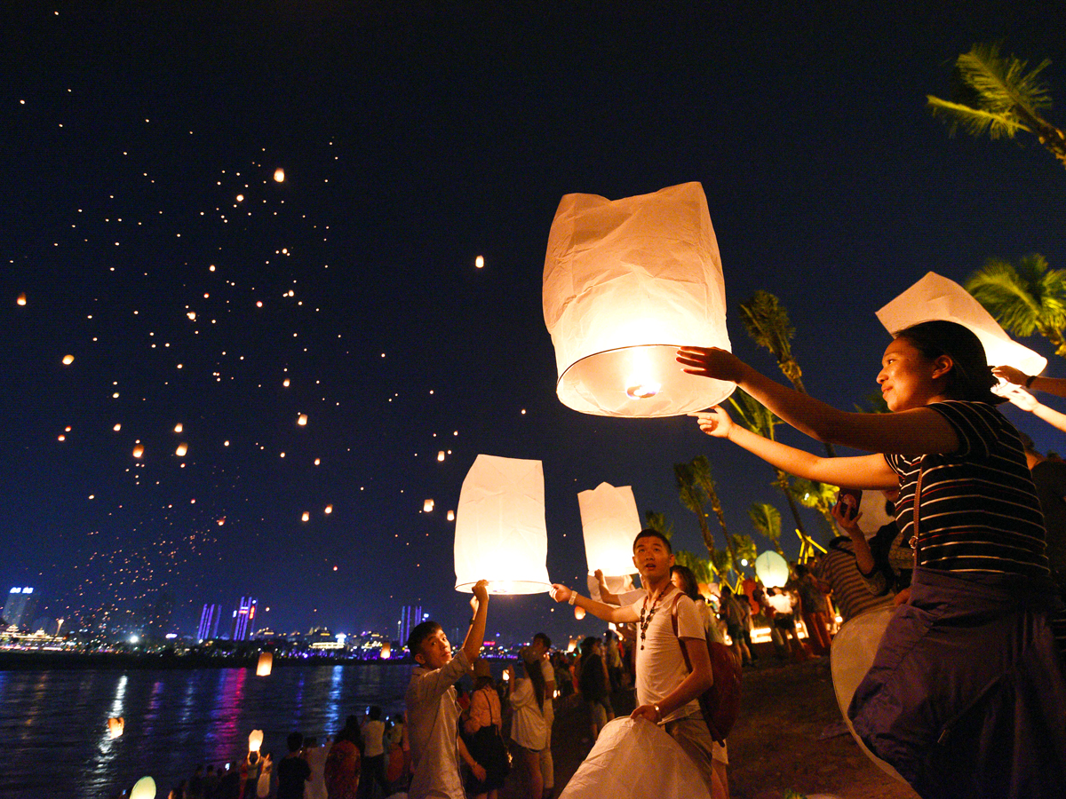 People setting lanterns into the night sky in Xishuangbanna, China
