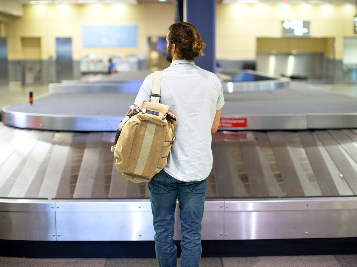 Traveler waiting at airport baggage claim carousel