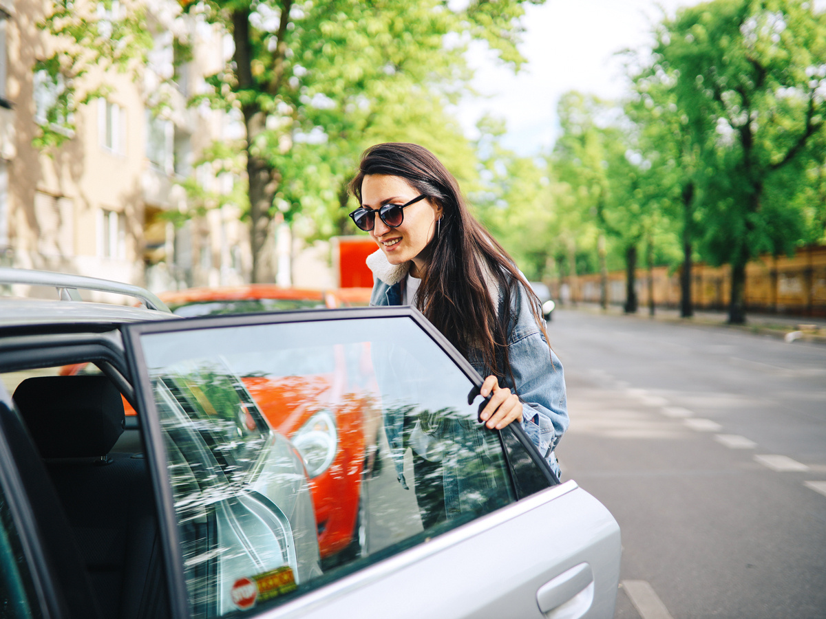 Woman stepping into rideshare vehicle