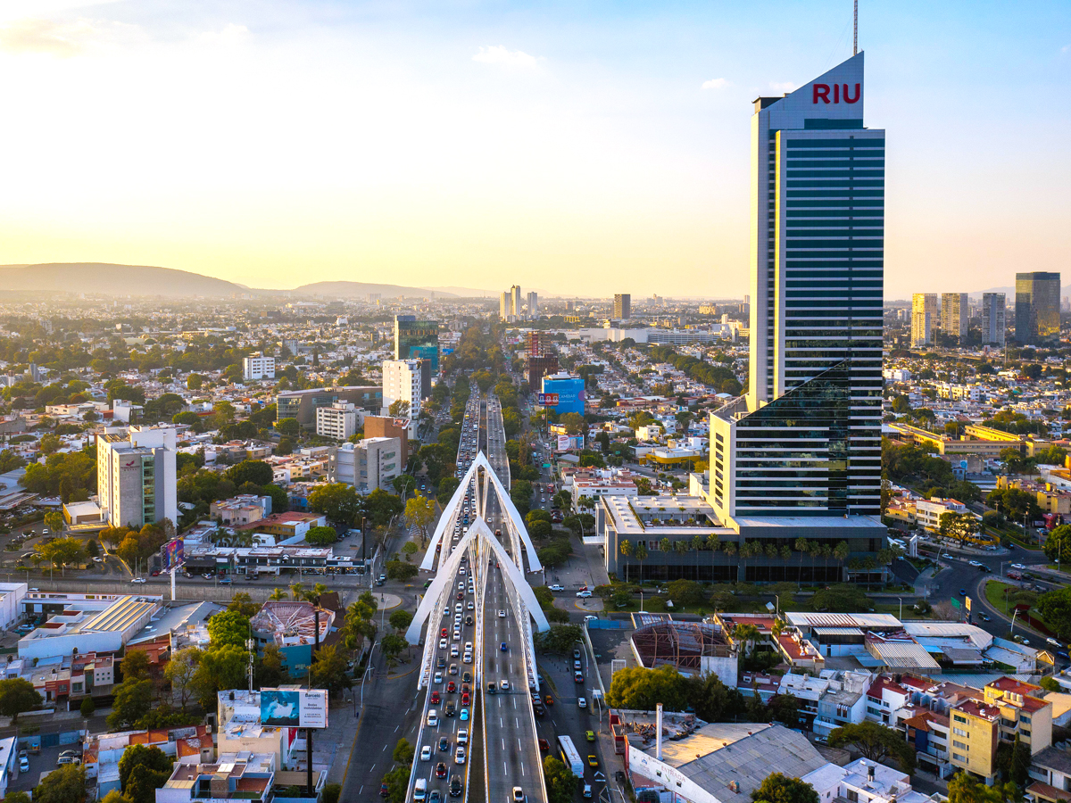Hotel Riu Plaza Guadalajara towering above city skyline at sunset