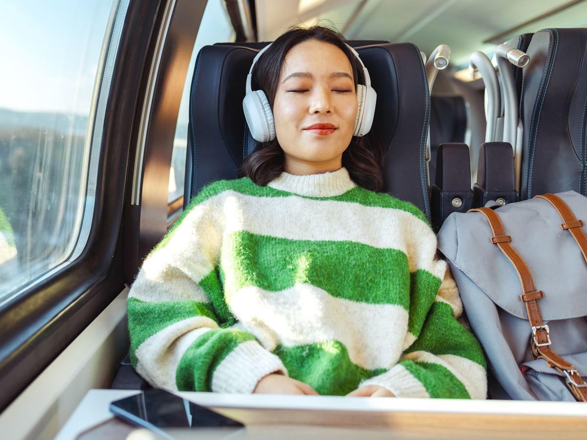 Train passenger wearing noise-canceling headphones