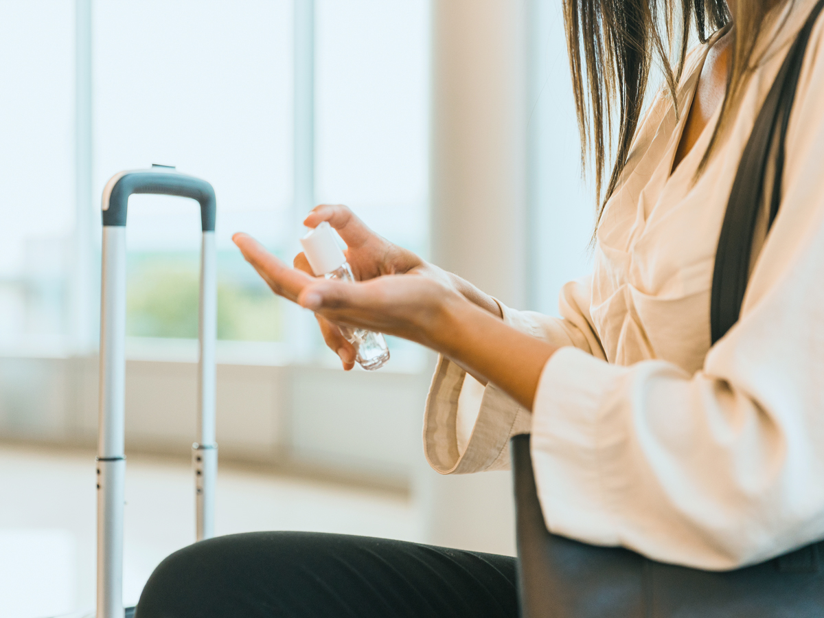 Traveler applying hand sanitizer