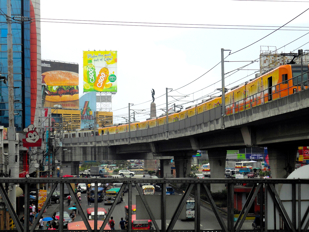 Elevated train above busy street in Caloocan, the Philippines