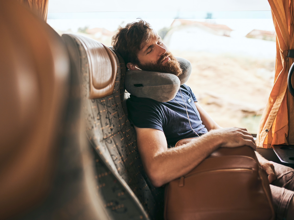 Train passenger sleeping with neck pillow