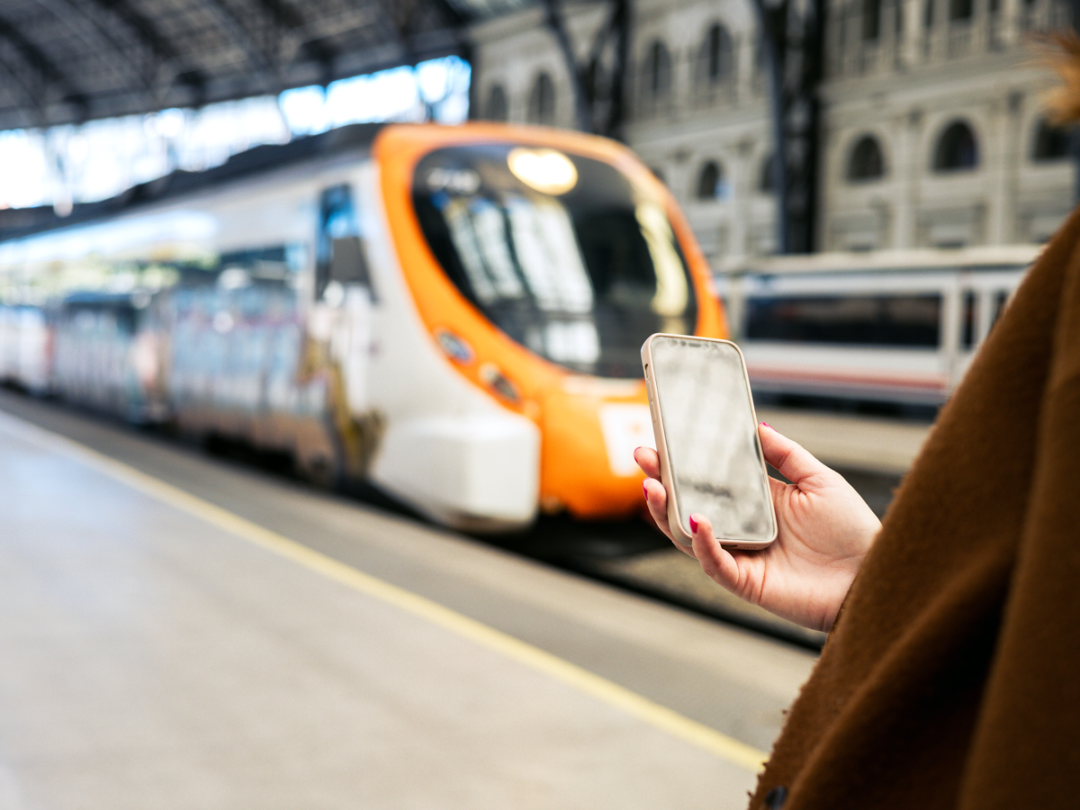 Traveler holding phone in train station