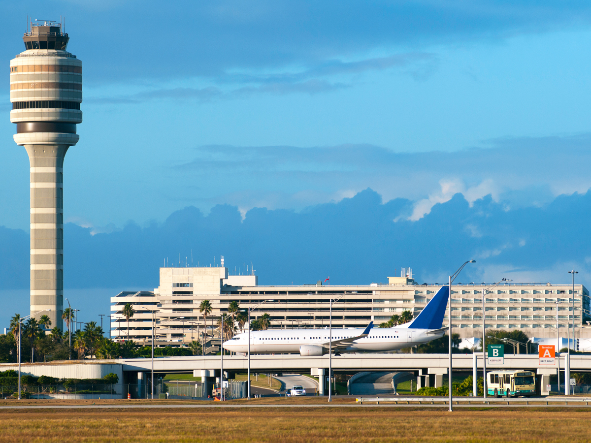 Aircraft taxiing with view of control tower at Orlando International Airport