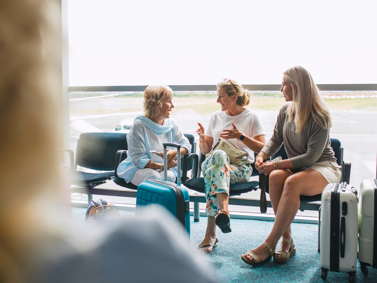 Group of passengers sitting at airport gate