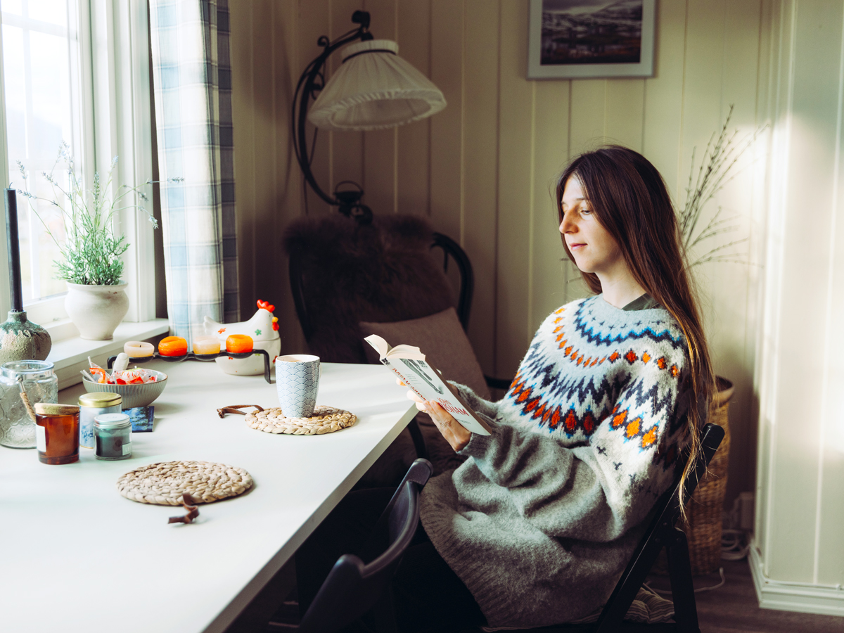 Person sitting at table reading book