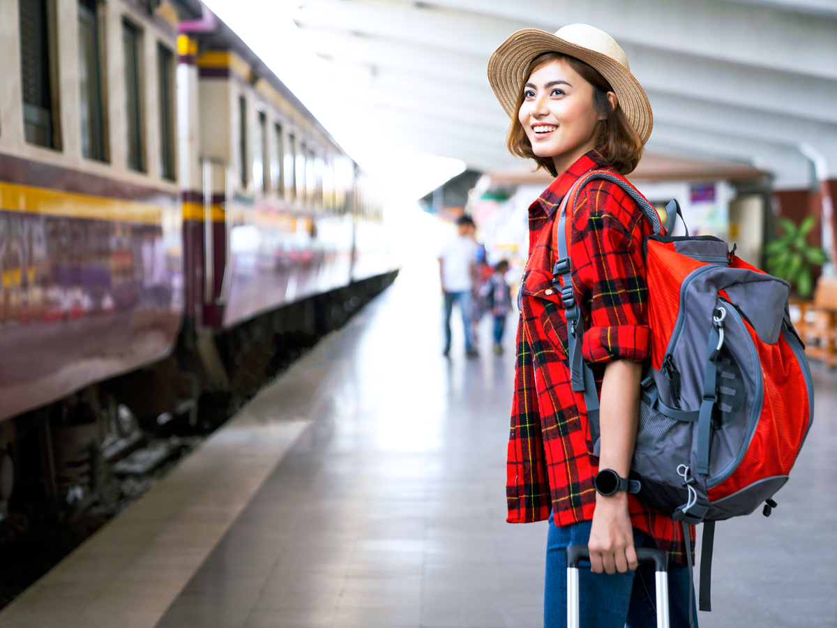 Passenger waiting on train platform with luggage