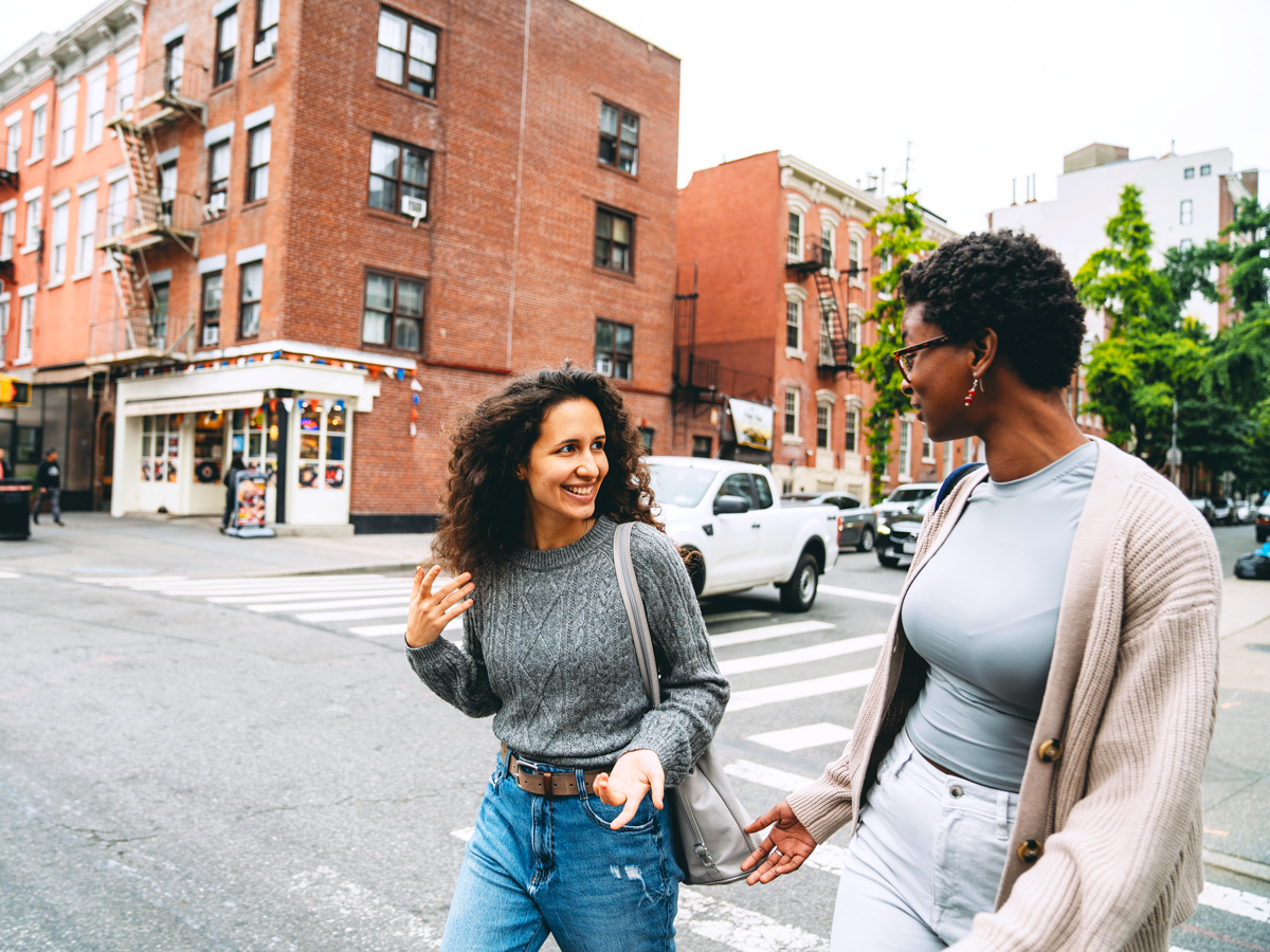 Two people talking and crossing street