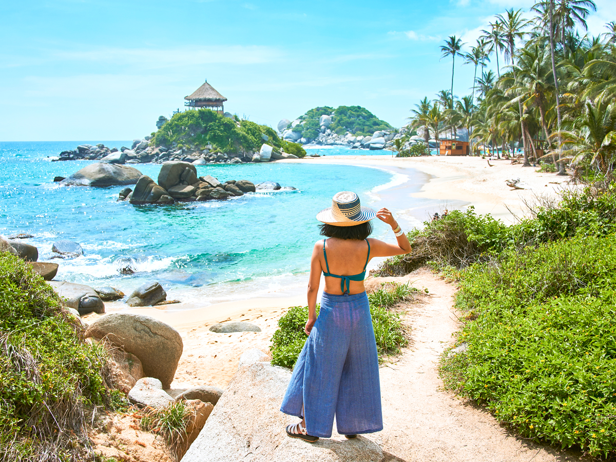 Person wearing hat walking to beach
