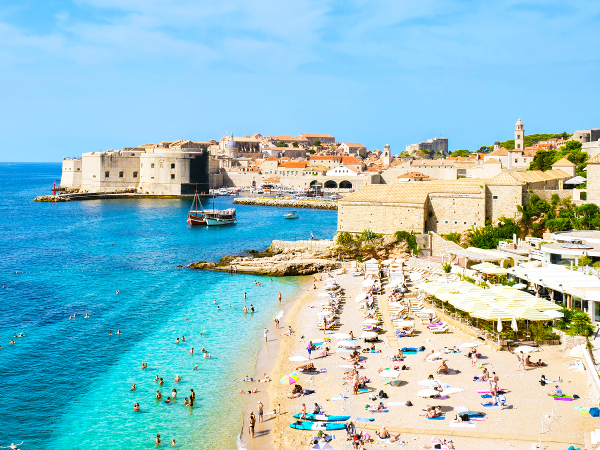 Crowded beach with walled old city of Dubrovnik in background