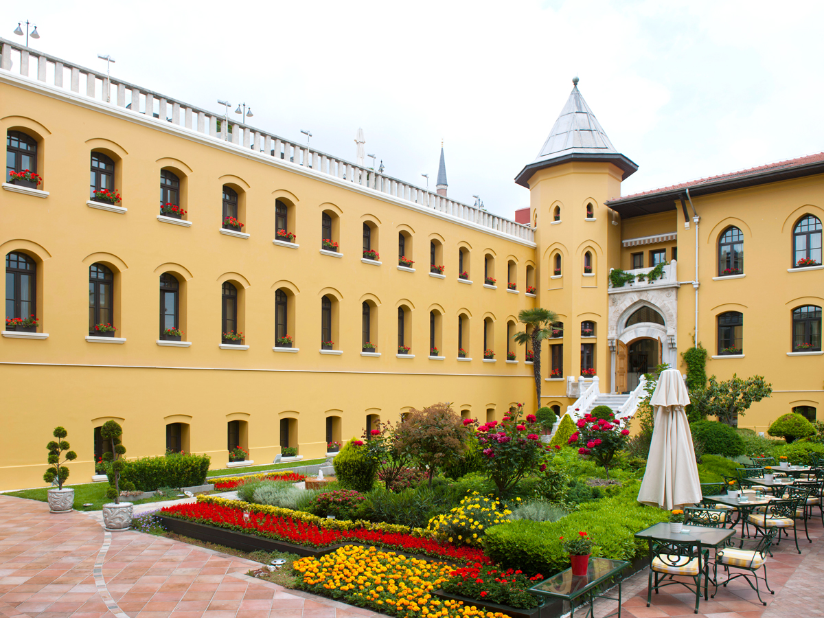 Courtyard and brightly painted exterior walls of the Four Seasons Hotel Istanbul at Sultanahmet
