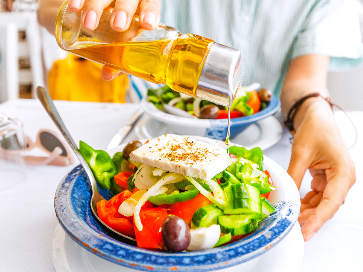 Person making Greek salad