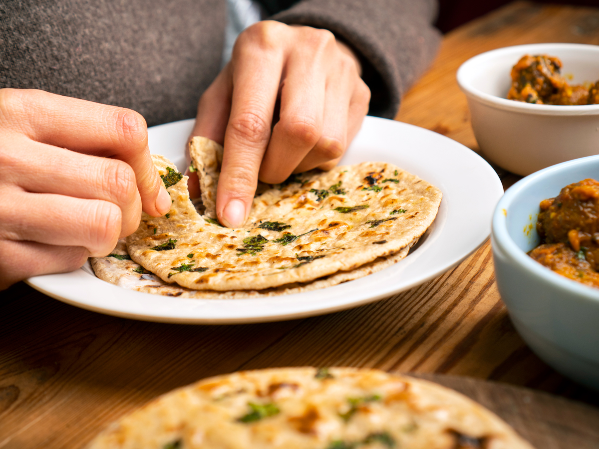 Diner eating flatbread with hands
