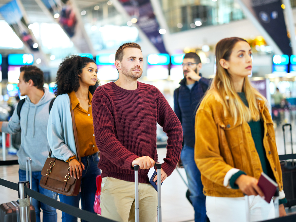 Airline passengers standing in line at airport