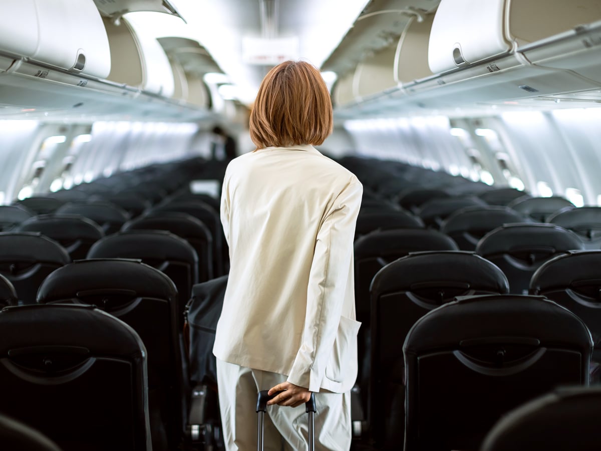 Airline passenger walking down aircraft aisle